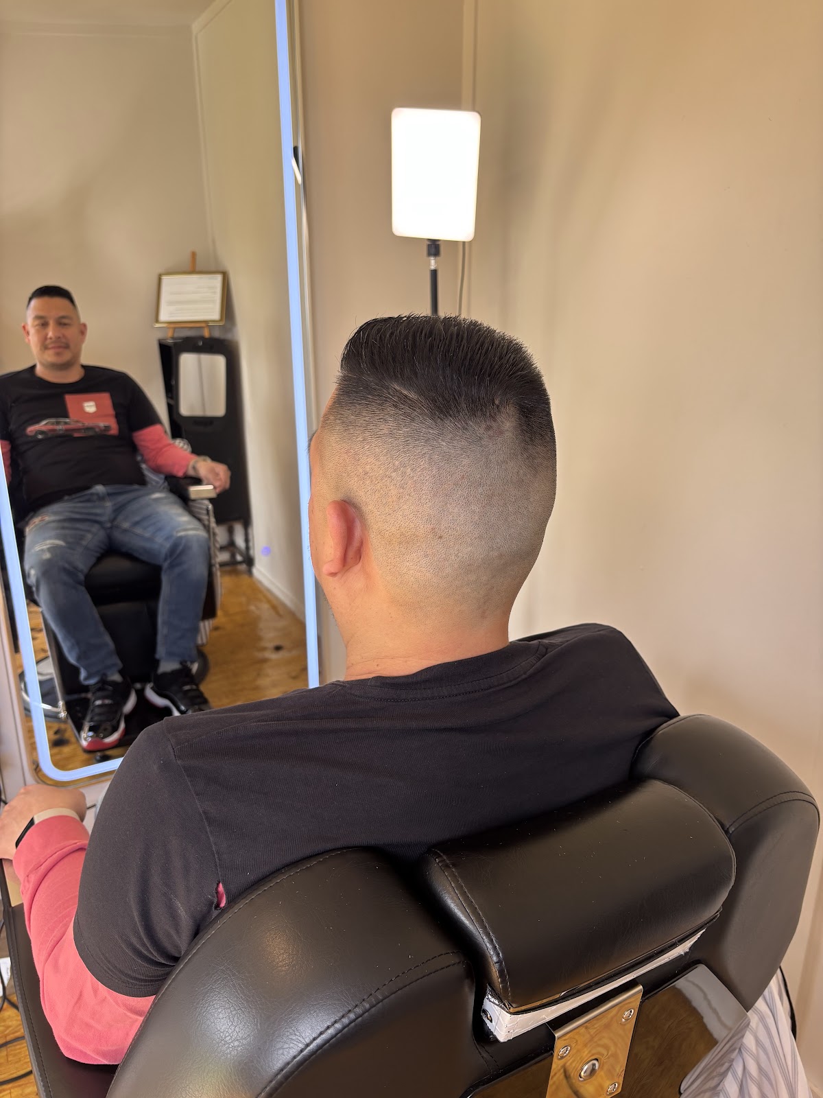 High skin fade with a flat top, styled in the mirror room