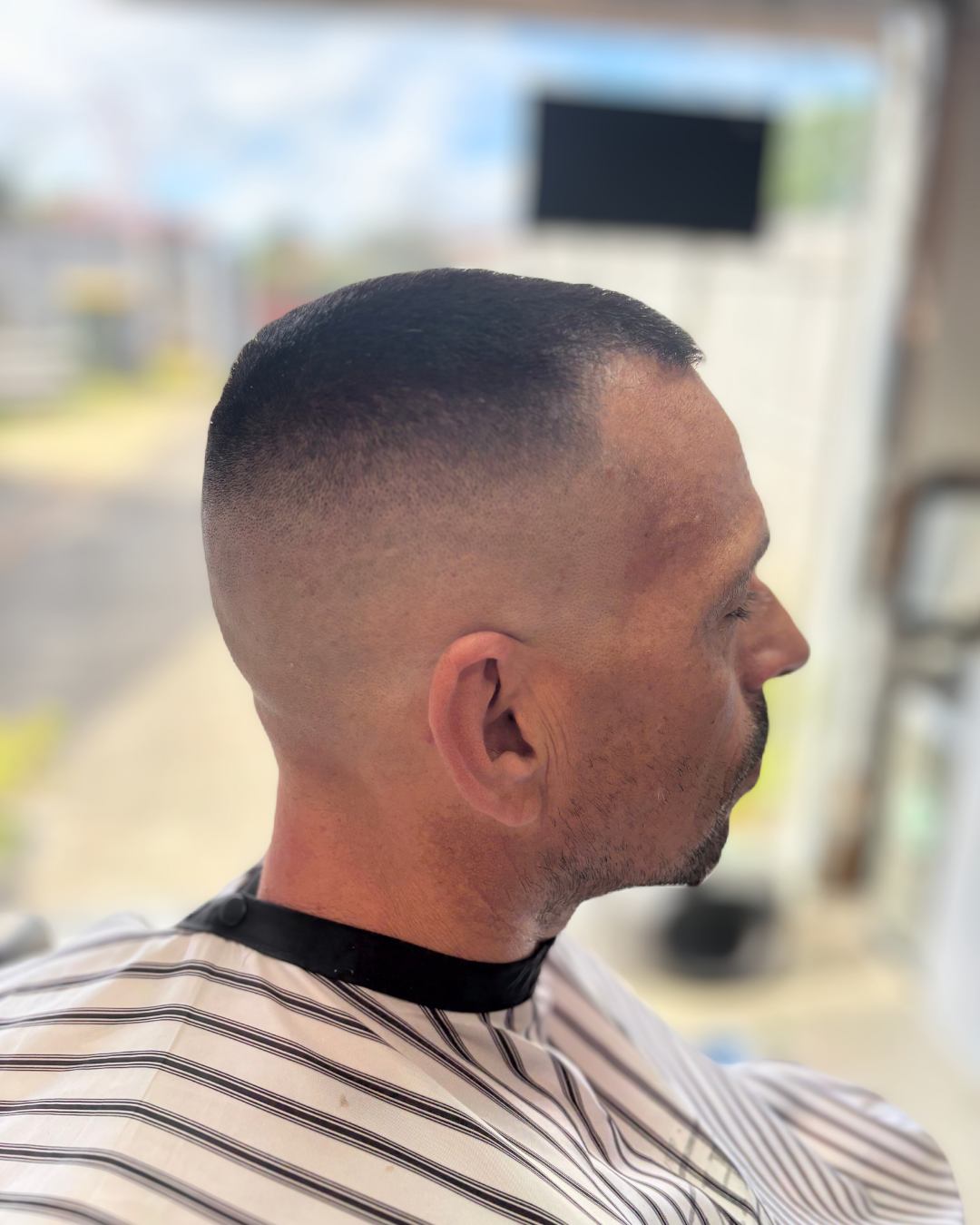 High and tight skin fade, side profile in daylight